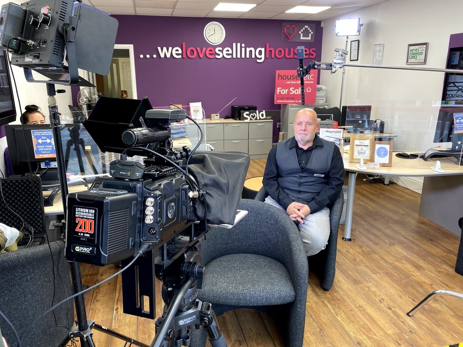 Lights and a cinema camera set up for an interview in an estate agency showroom