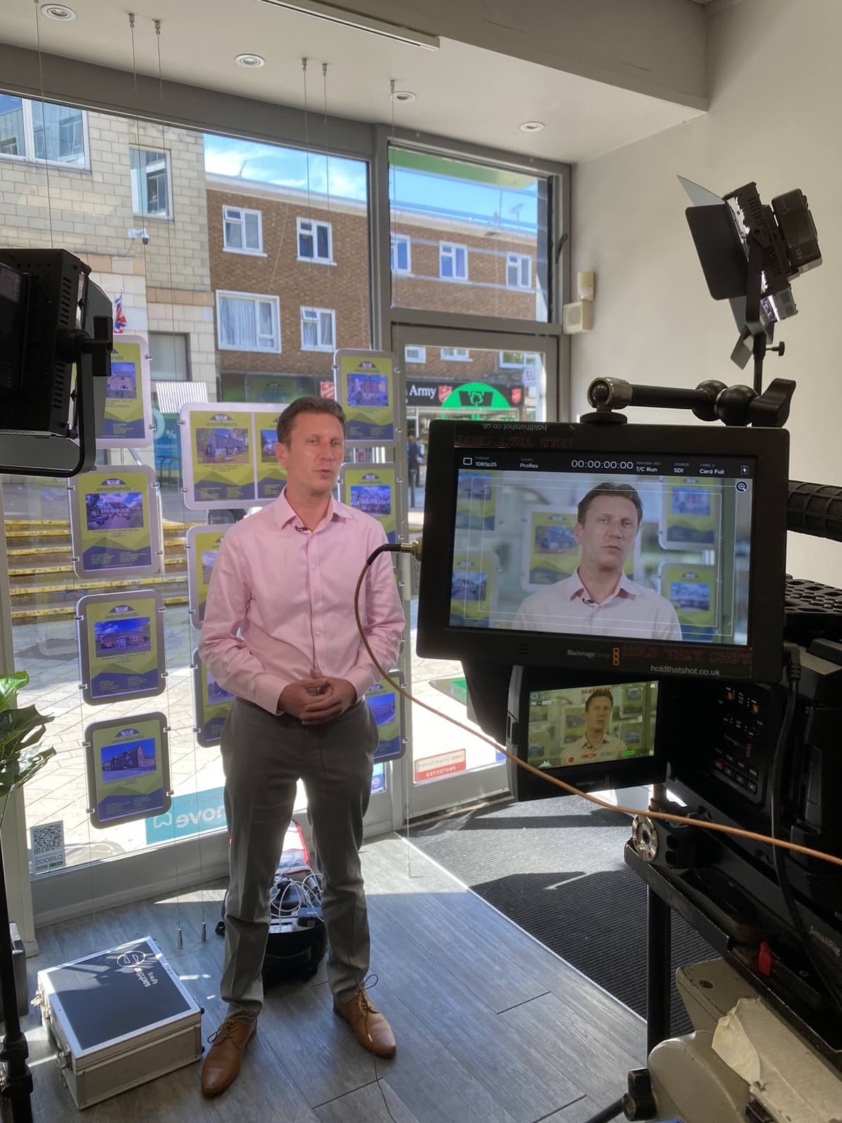 An agent presenting to camera in front of the agency's window display