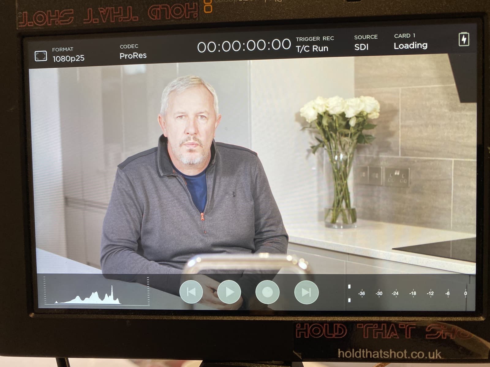 A Hold That Shot camera monitor showing an interview being recorded in a kitchen