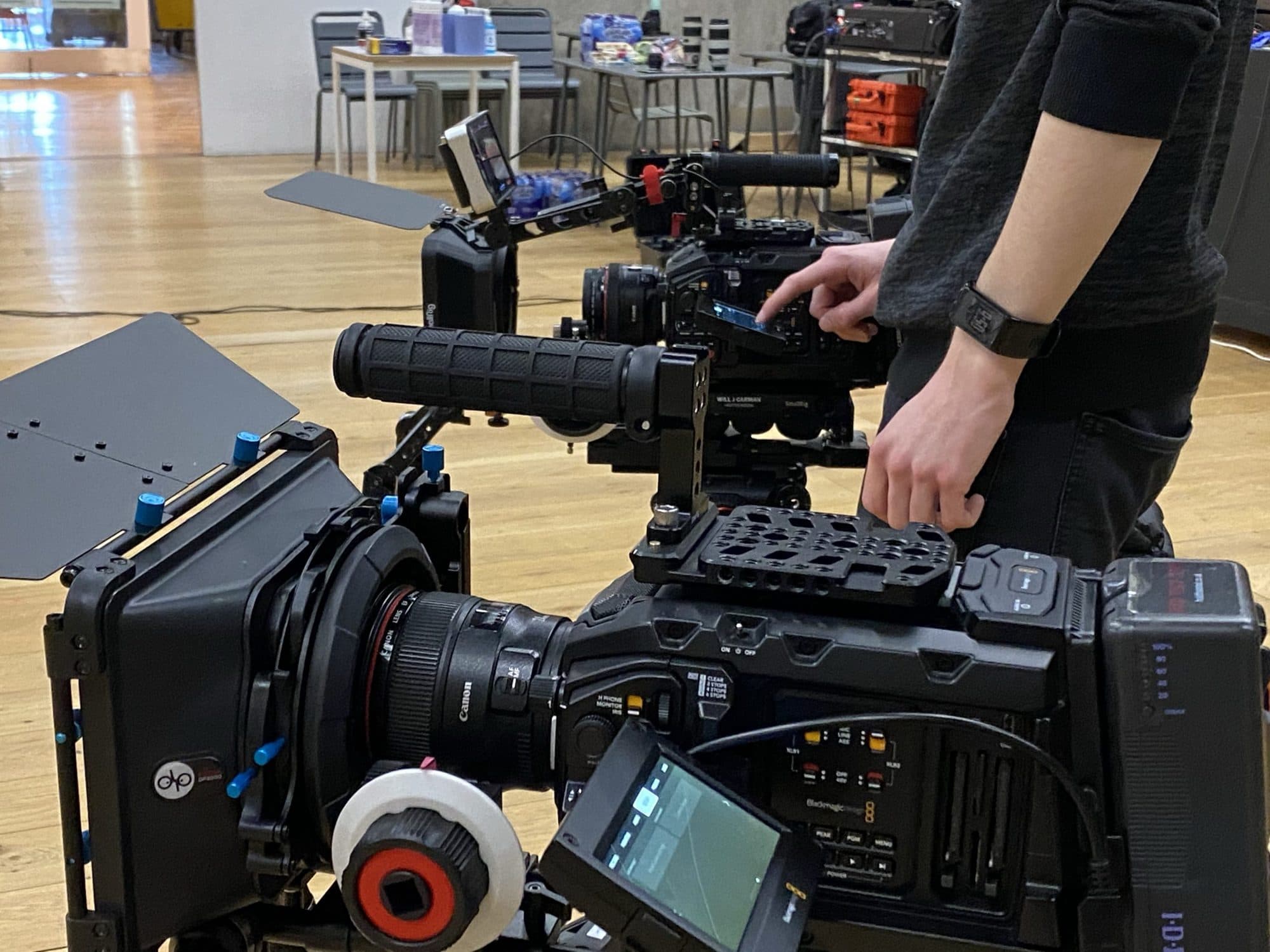 A cinema camera with a matte box and follow focus being set up for a shoot